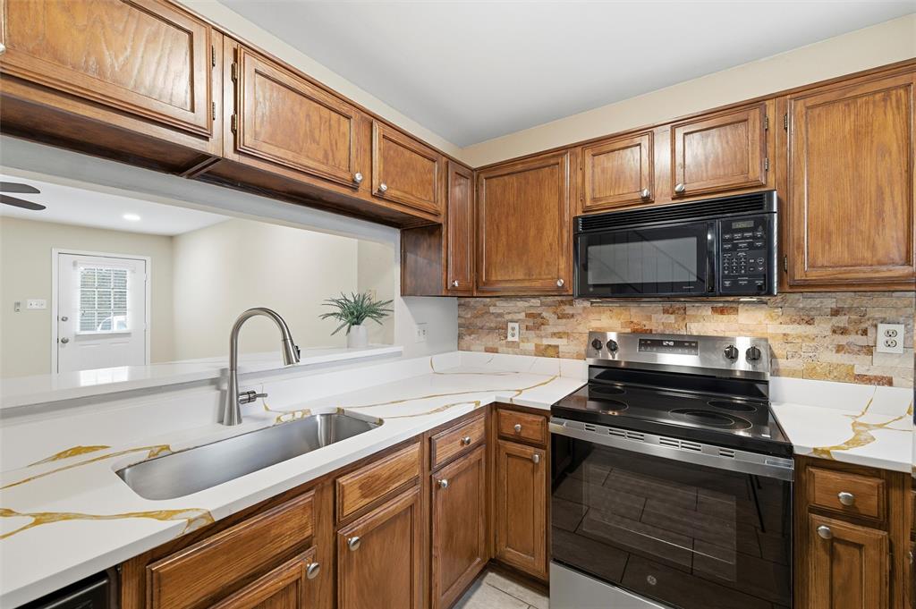 112 Churchill Lane Euless, TX 76039 - Photo 4 of 33 a kitchen with granite countertop a sink stainless steel appliances and cabinets