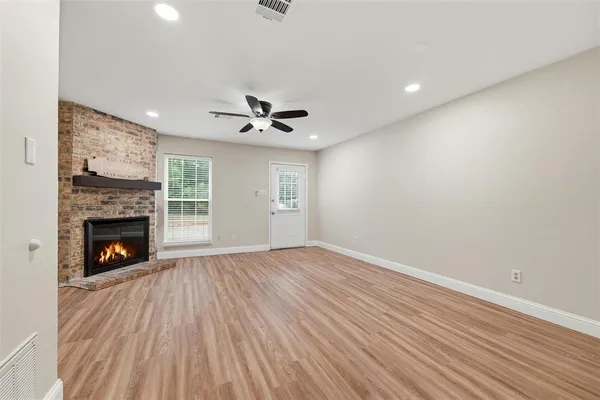 a view of empty room with wooden floor and fireplace