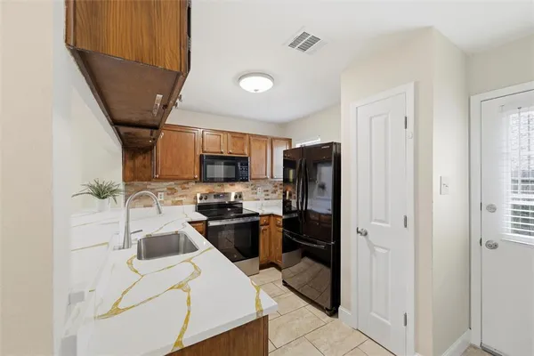 a kitchen with stainless steel appliances a refrigerator stove microwave and sink