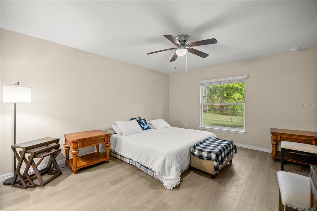 13131 Southwest 73rd Street Ocala, FL 34481 - Photo 13 of 30 a bedroom with a bed and a chandelier