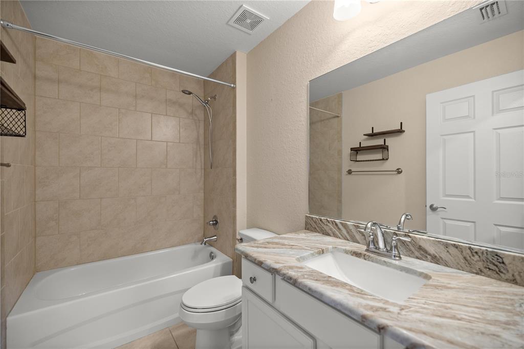 13131 Southwest 73rd Street Ocala, FL 34481 - Photo 20 of 30 a bathroom with a granite countertop sink a toilet and shower