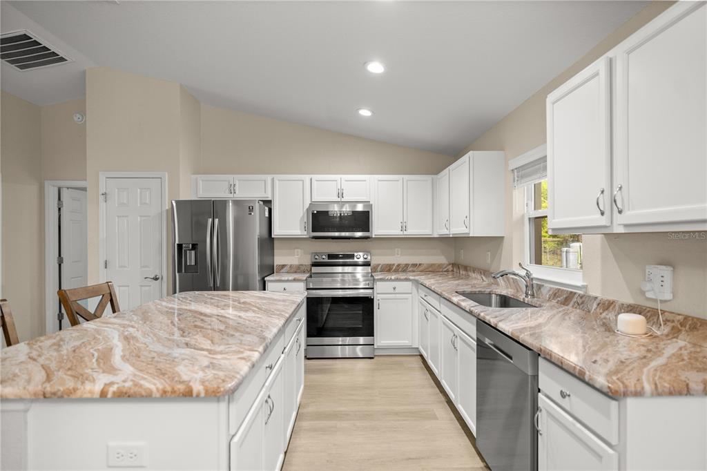 13131 Southwest 73rd Street Ocala, FL 34481 - Photo 8 of 30 a kitchen with stainless steel appliances granite countertop a sink stove and refrigerator