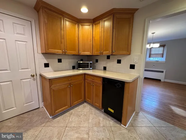 a kitchen with stainless steel appliances a sink a stove a refrigerator cabinets and a dining table