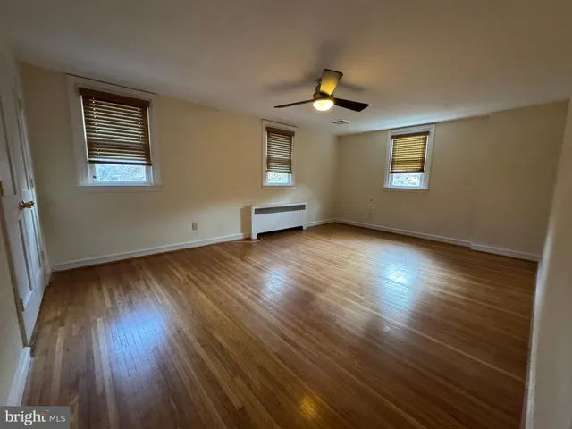 a view of an empty room with wooden floor