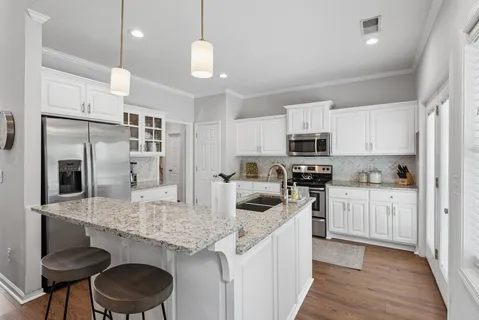 a kitchen with granite countertop stainless steel appliances a sink microwave and stove