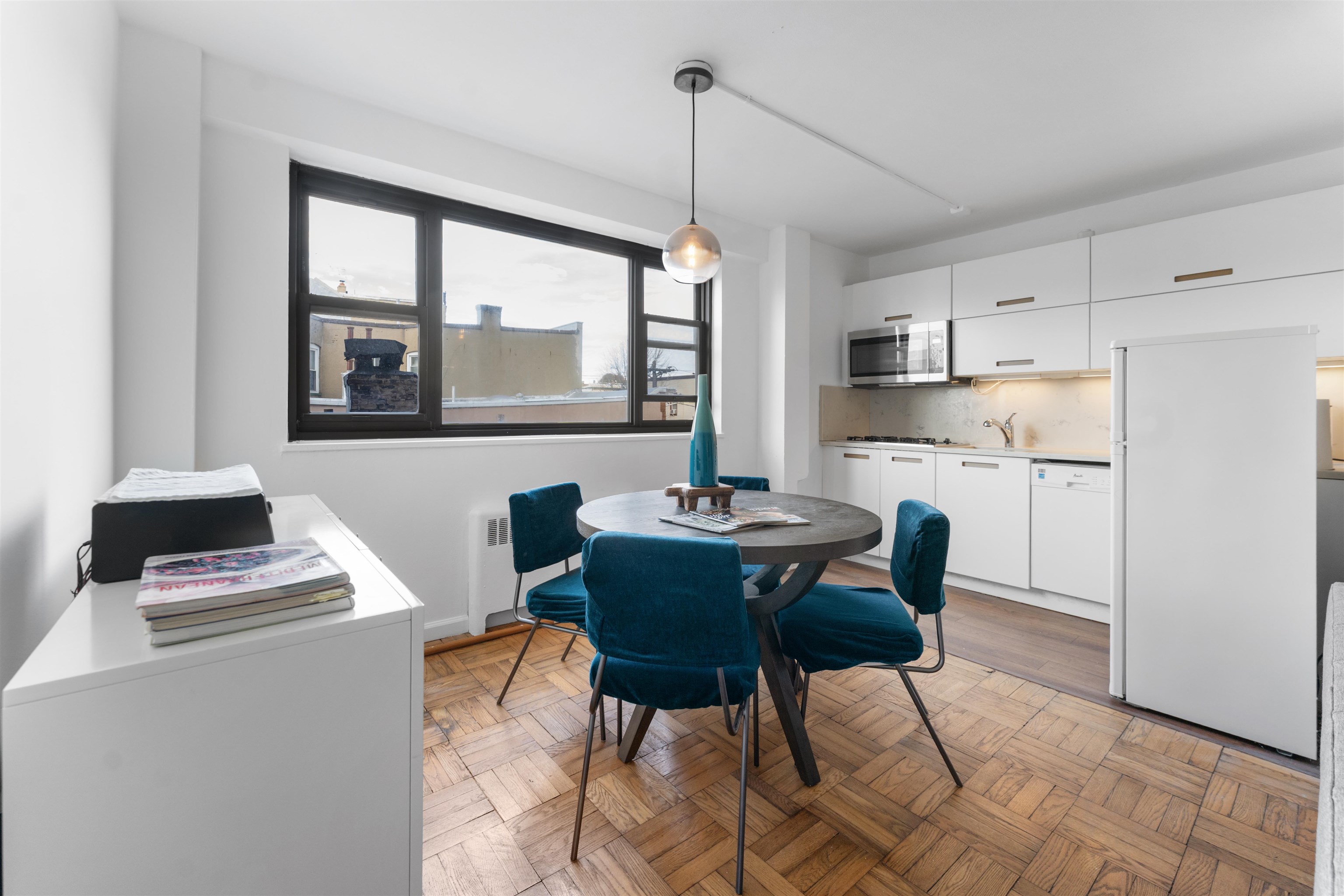 6515 JFK Boulevard East, Unit 4C West New York, NJ 07093 - Photo 4 of 14 a kitchen with a dining table chairs and white cabinets