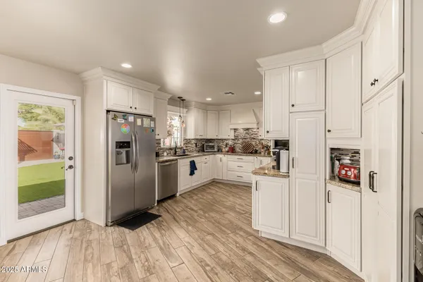 a kitchen with white cabinets and stainless steel appliances