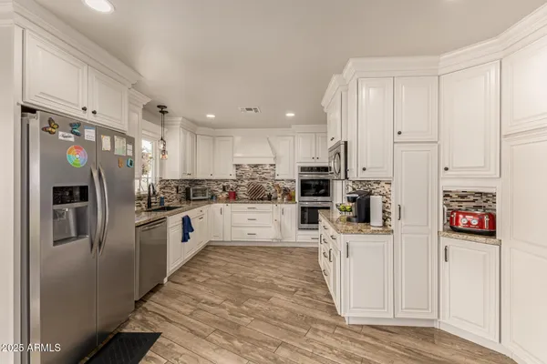 a kitchen with stainless steel appliances a refrigerator sink and cabinets