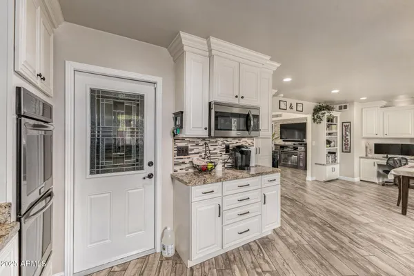 a kitchen with stainless steel appliances kitchen island granite countertop a stove and a sink
