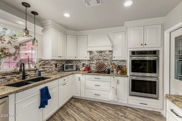 a kitchen with stainless steel appliances granite countertop a sink and a stove