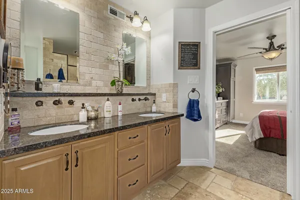 a spacious en suite bathroom with double sink and a mirror