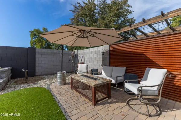 a view of a backyard with table and chairs under an umbrella