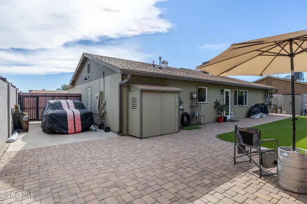 a view of a chair and table in backyard of the house