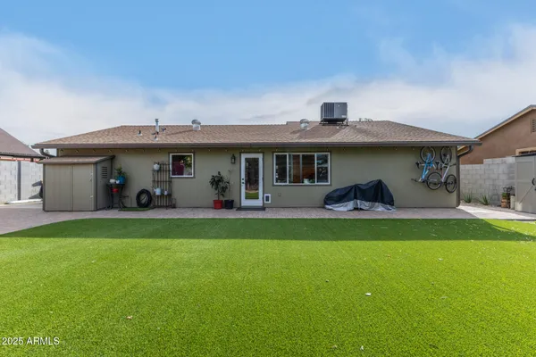 a view of a house with a patio and a yard