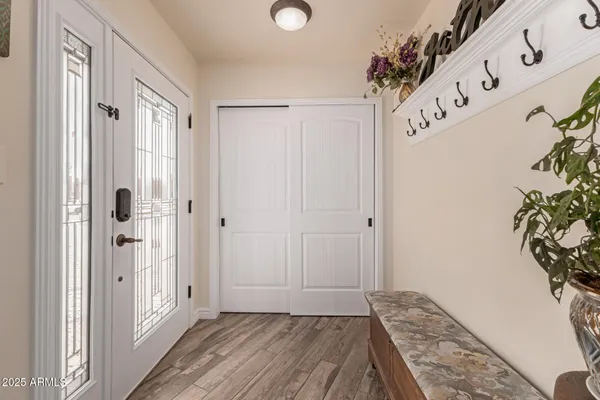 a view of a hallway with wooden floor and front door