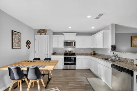 a kitchen with stainless steel appliances kitchen island granite countertop a sink and cabinets