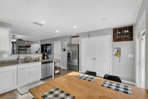 a kitchen with stainless steel appliances kitchen island granite countertop a refrigerator and a sink