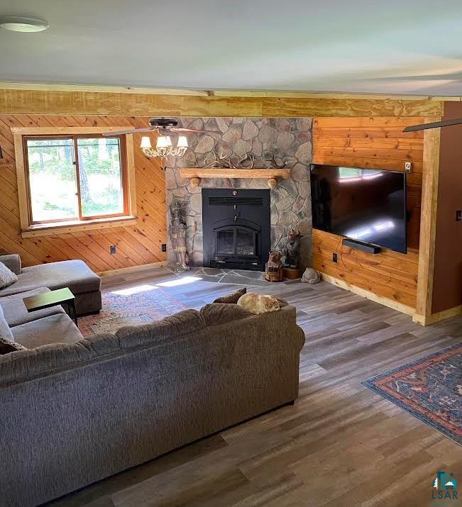 1896 Echo Trail Ely, MN 55731 - Photo 18 of 20 Living room featuring wood walls, wood finished floors, and a stone fireplace