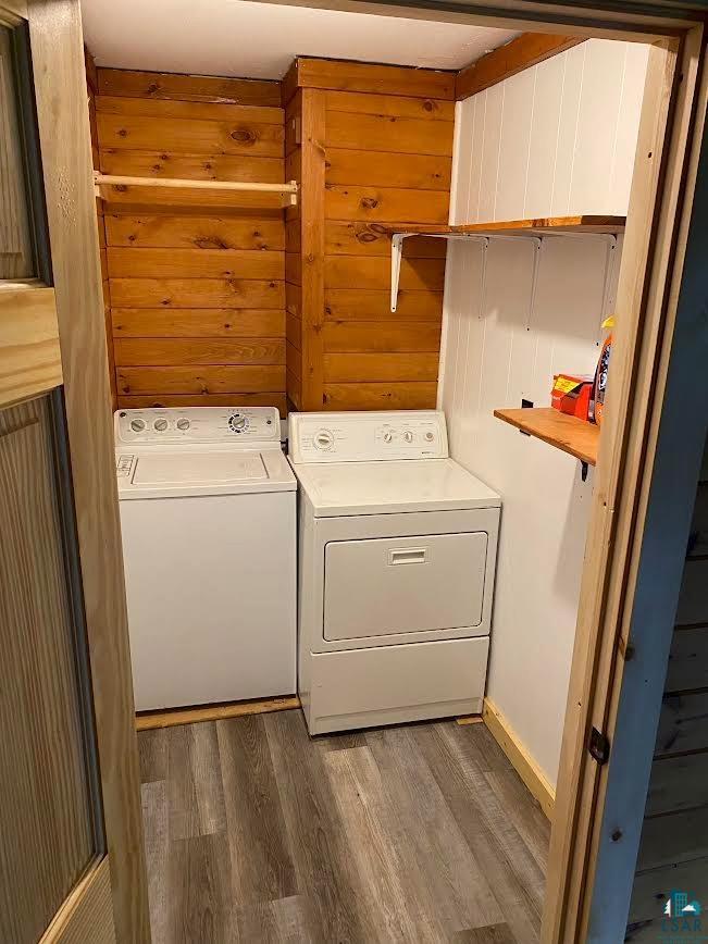 1896 Echo Trail Ely, MN 55731 - Photo 10 of 20 Washroom with light wood finished floors, separate washer and dryer, and wooden walls