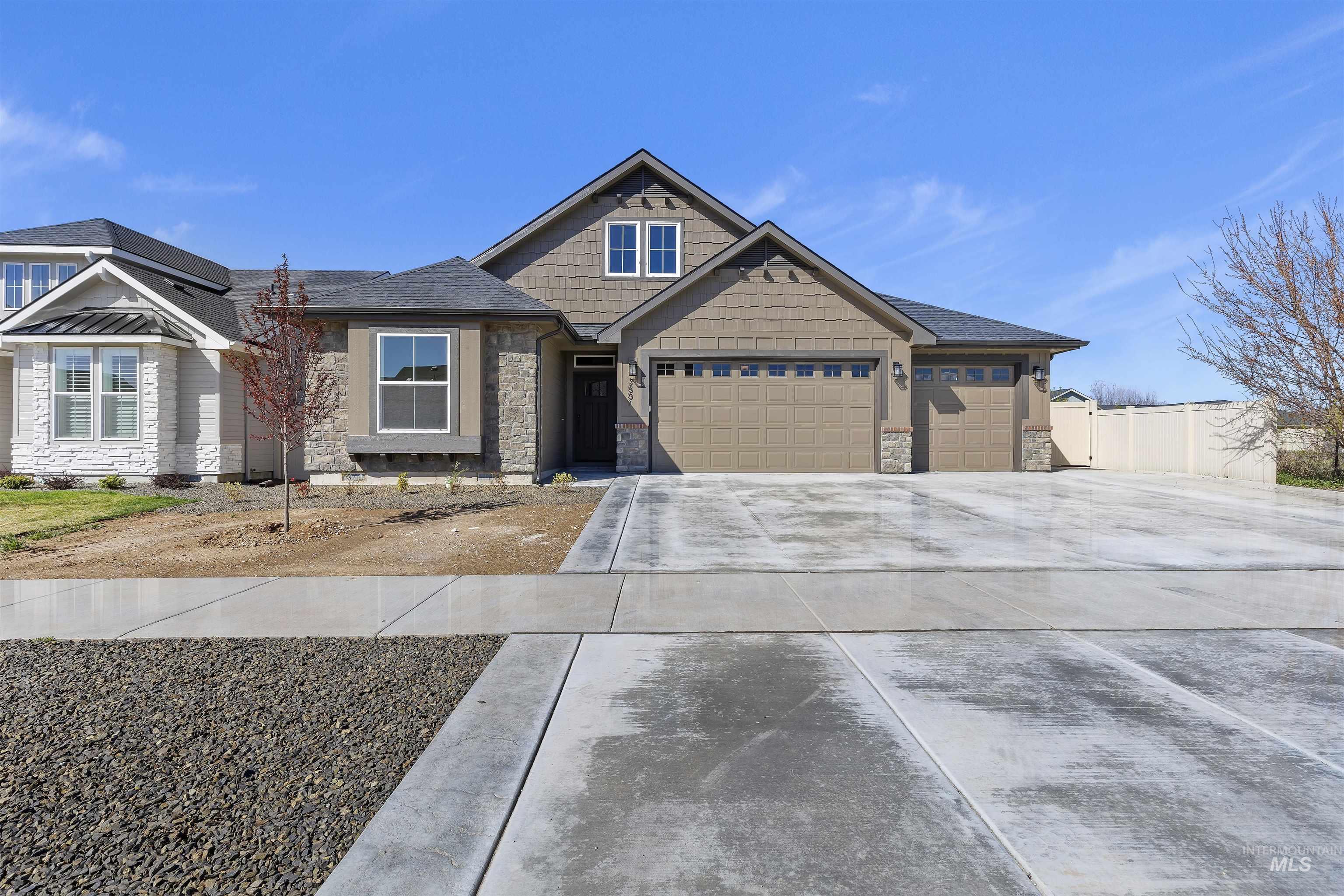 Craftsman house featuring an attached garage, driveway, and stone siding