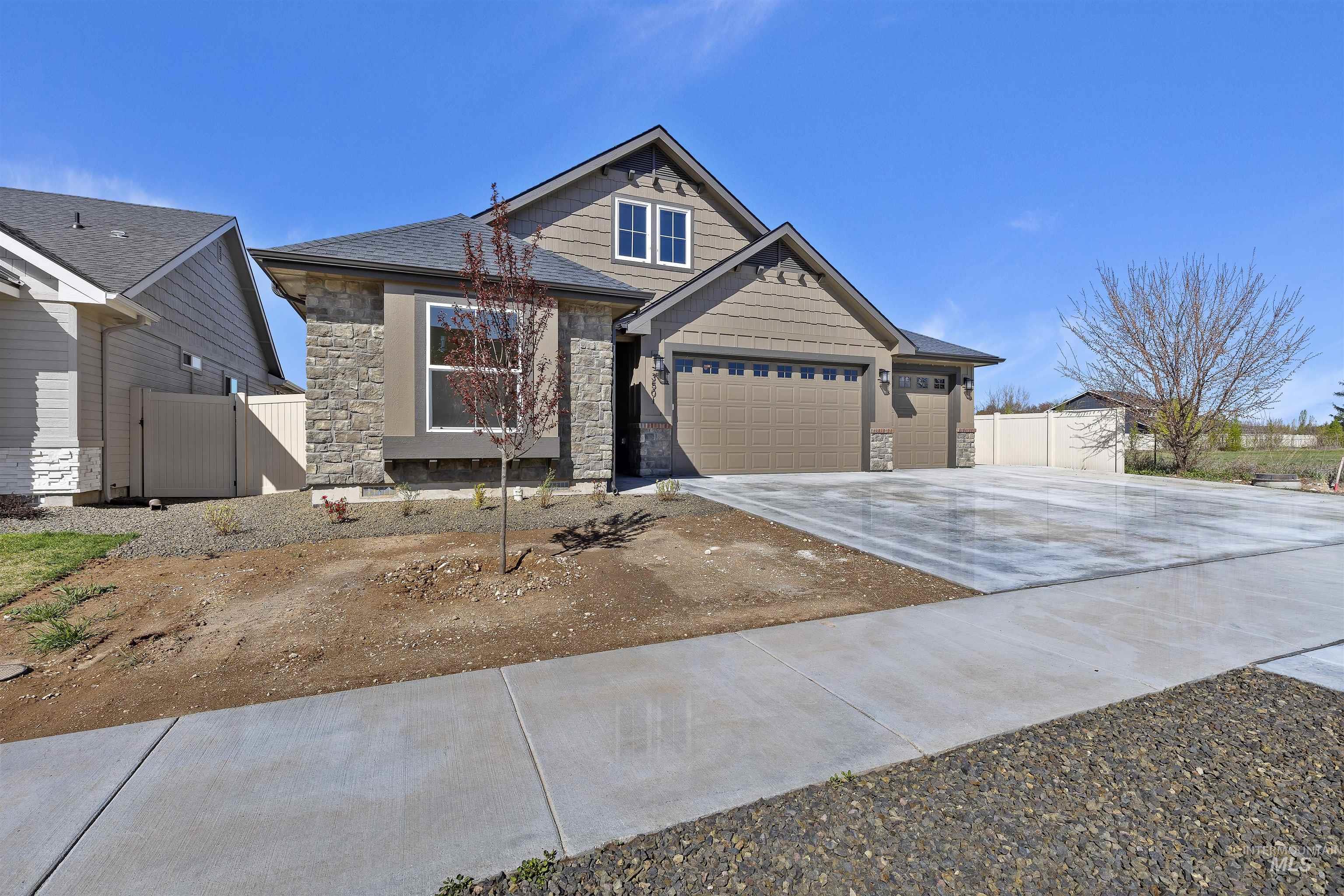 3501 South El Rio Avenue Boise, ID 83709 - Photo 2 of 31 Craftsman house featuring stone siding, concrete driveway, an attached garage, and a gate