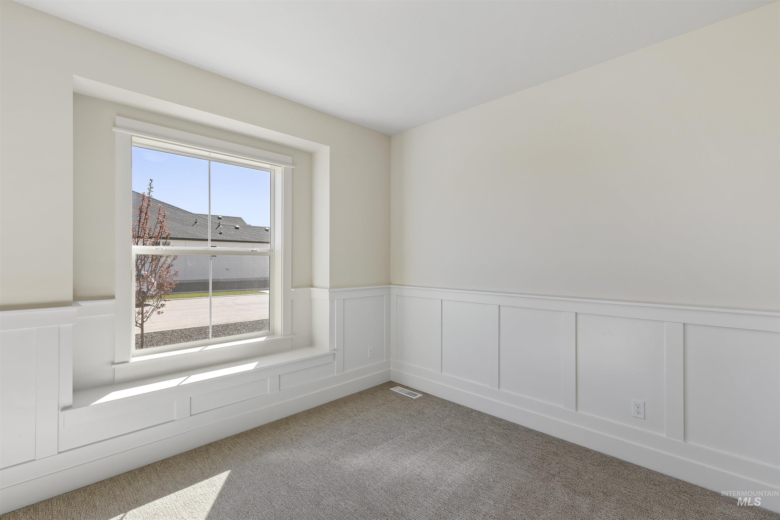 3501 South El Rio Avenue Boise, ID 83709 - Photo 23 of 31 Spare room featuring wainscoting, a decorative wall, and light carpet