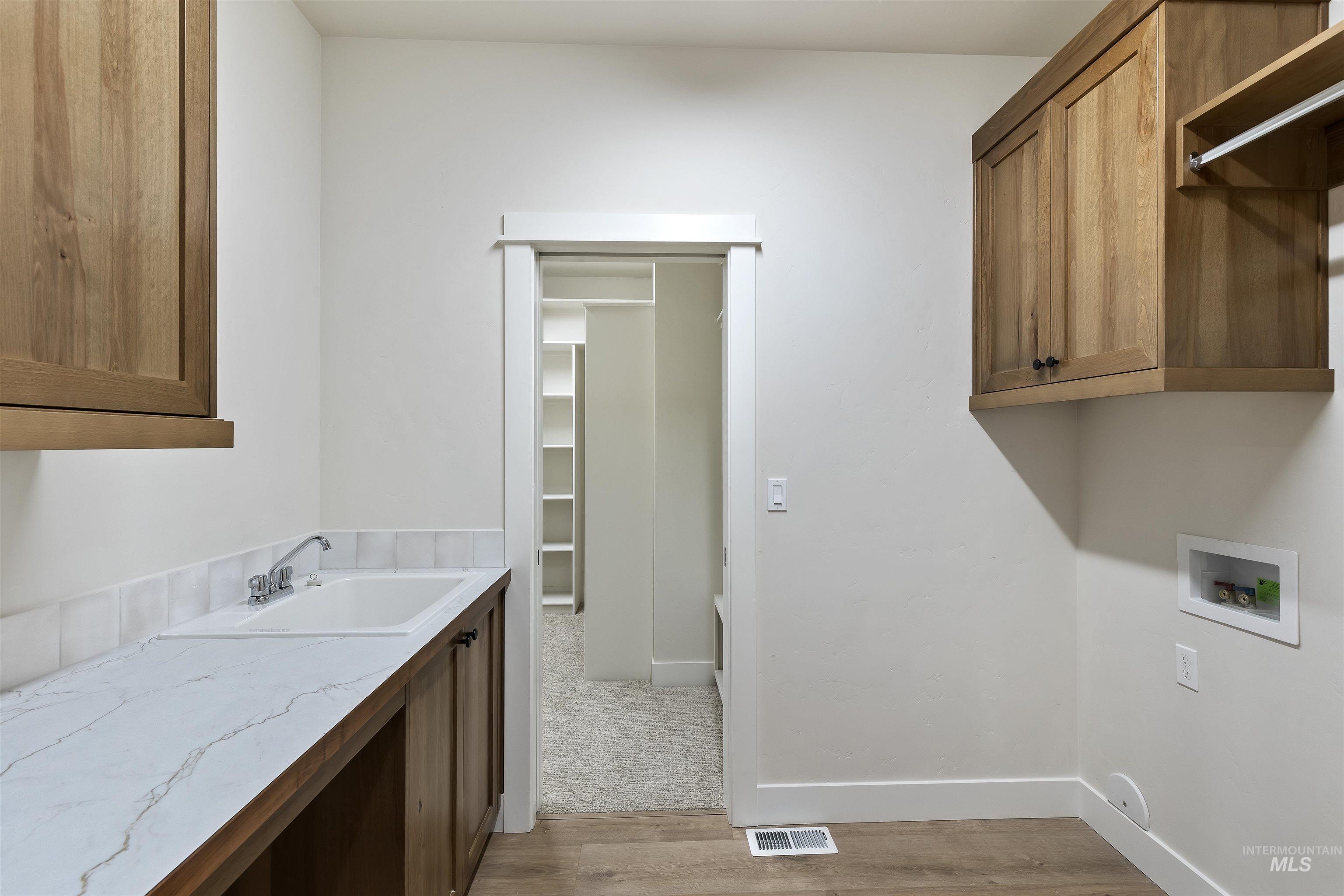 3501 South El Rio Avenue Boise, ID 83709 - Photo 28 of 31 Laundry area with cabinet space, light wood-style flooring, and washer hookup