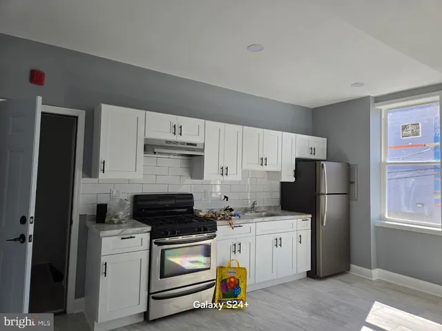 a kitchen with a refrigerator stove and white cabinets
