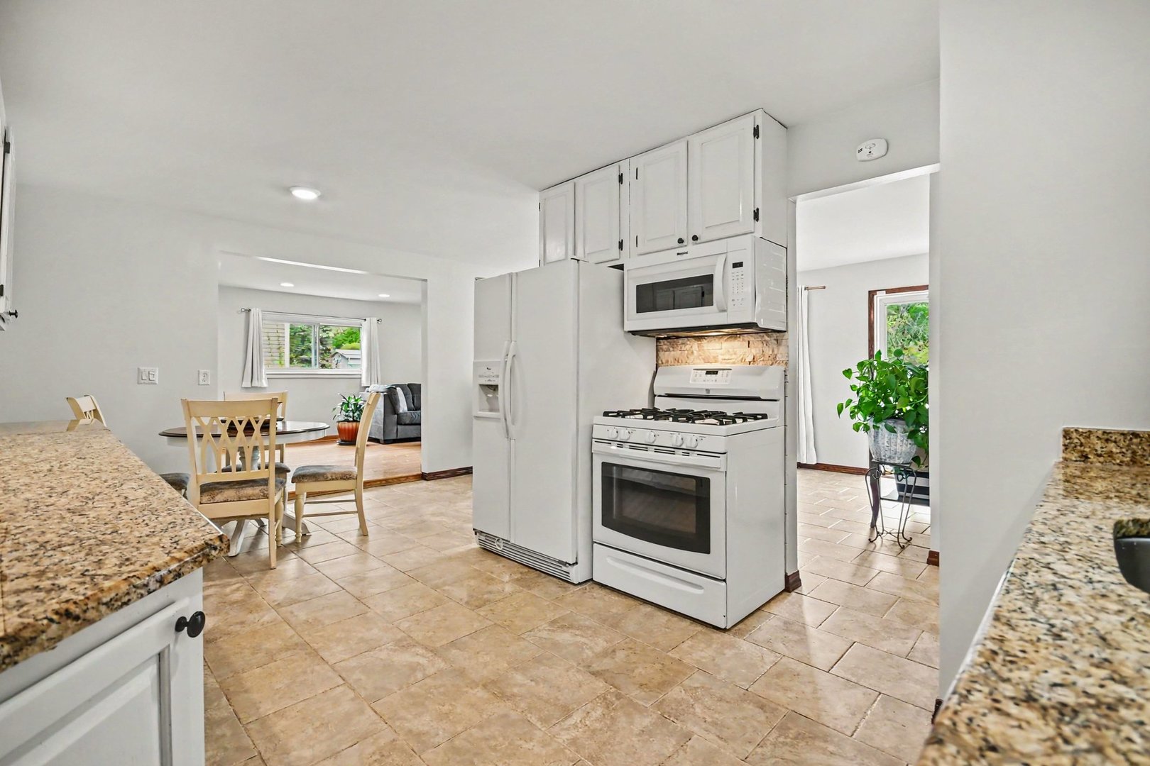 48 Pueblo Road Montgomery, IL 60538 - Photo 9 of 33 a kitchen with granite countertop a stove a sink and a refrigerator