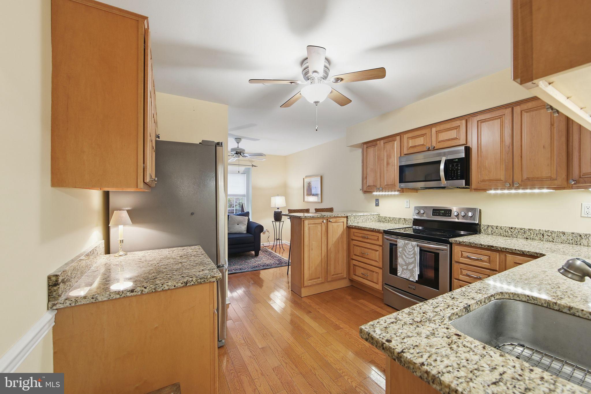 201 Penns Lane, Unit 201 Malvern, PA 19355 - Photo 12 of 30 a kitchen with kitchen island granite countertop a sink appliances cabinets and furniture