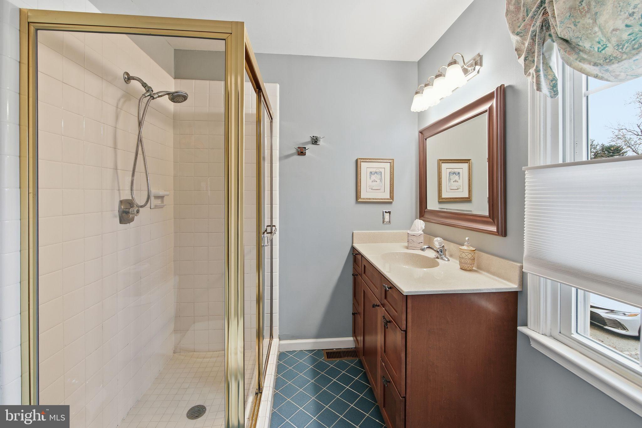 201 Penns Lane, Unit 201 Malvern, PA 19355 - Photo 20 of 30 a bathroom with a sink a mirror a vanity and shower