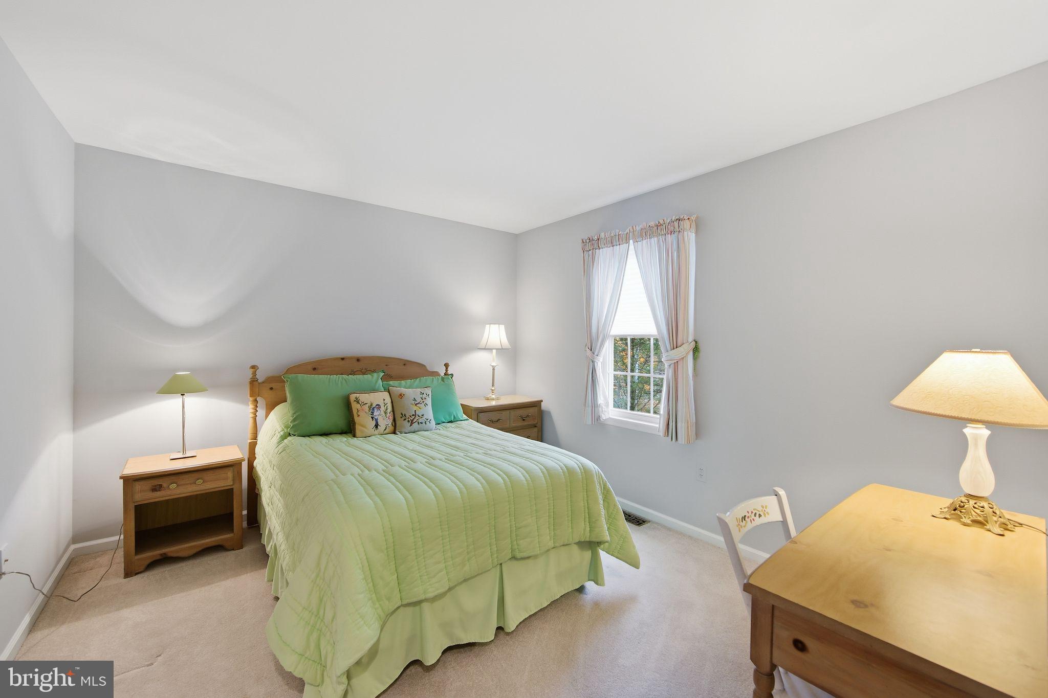 201 Penns Lane, Unit 201 Malvern, PA 19355 - Photo 24 of 30 a bedroom with a bed and a lamp