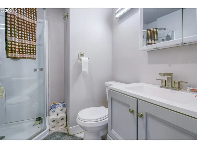 a bathroom with a sink a toilet and shower