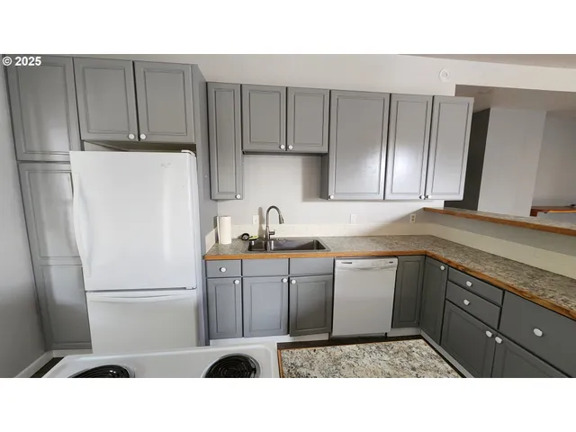 a kitchen with a refrigerator sink and cabinets