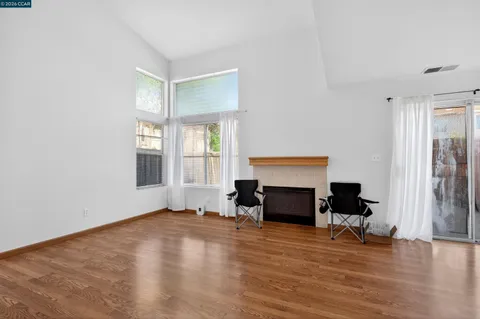a view of empty room with fireplace and wooden floor