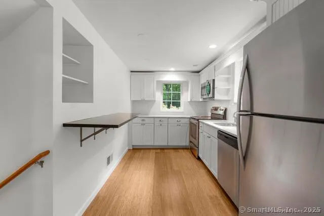 a kitchen with cabinets and wooden floor