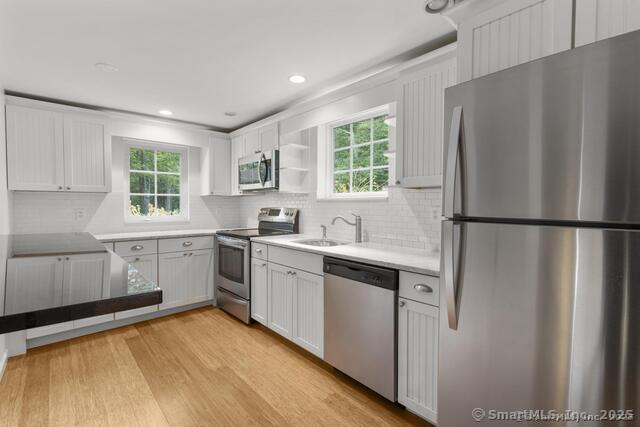 89 Book Hill Road Essex, CT 06426 - Photo 14 of 40 a kitchen with stainless steel appliances granite countertop a refrigerator a sink dishwasher a stove and white countertops with wooden floor
