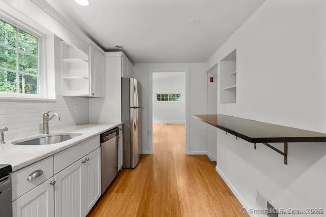 a kitchen with a sink and wooden floor