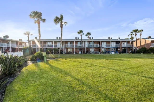 a view of a house with a big yard and large trees