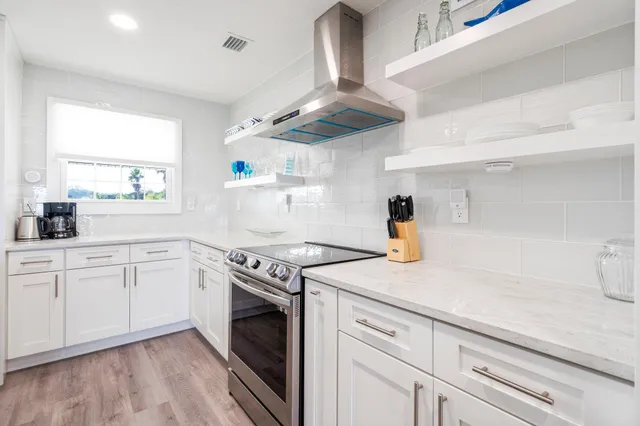 a kitchen with cabinets stainless steel appliances and wooden floor