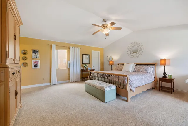 a spacious bedroom with a bed and a chandelier