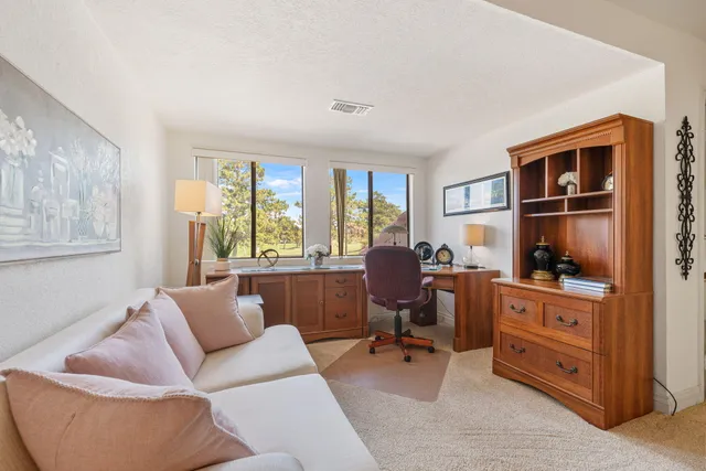 a view of a livingroom with workspace and a window