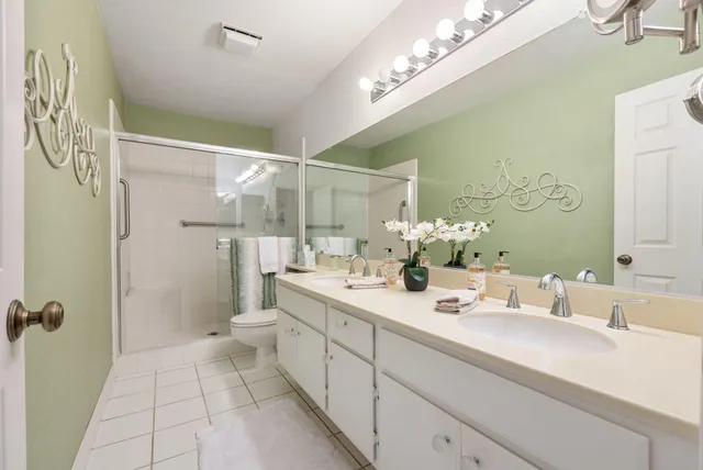 a bathroom with a double vanity sink mirror and shower