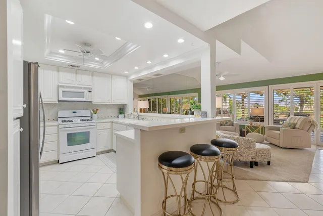 a kitchen with a dining table chairs refrigerator and cabinets