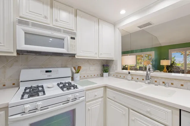 a kitchen with white cabinets and white appliances