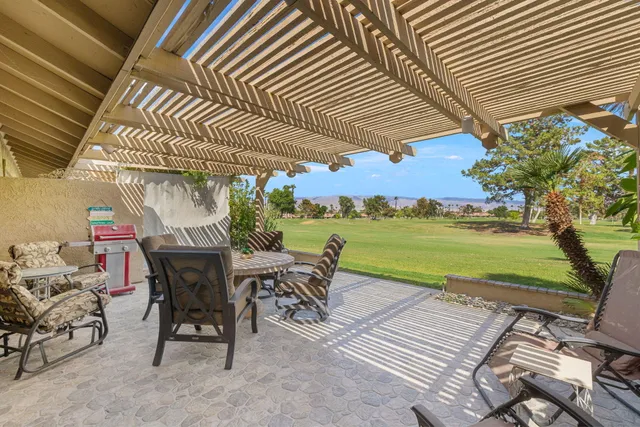 a view of a patio with a table and chairs under an umbrella