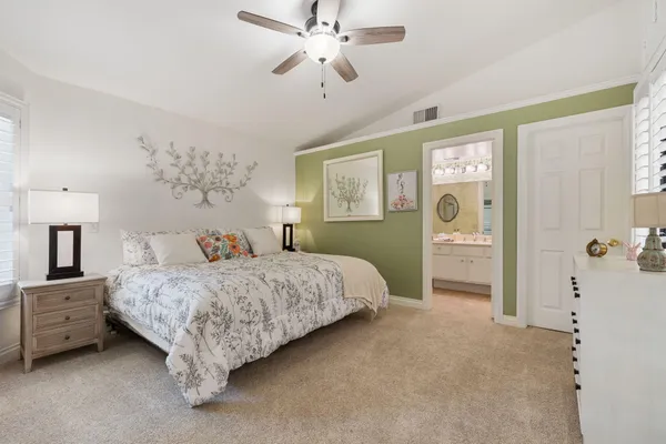 a spacious bedroom with a bed and a chandelier