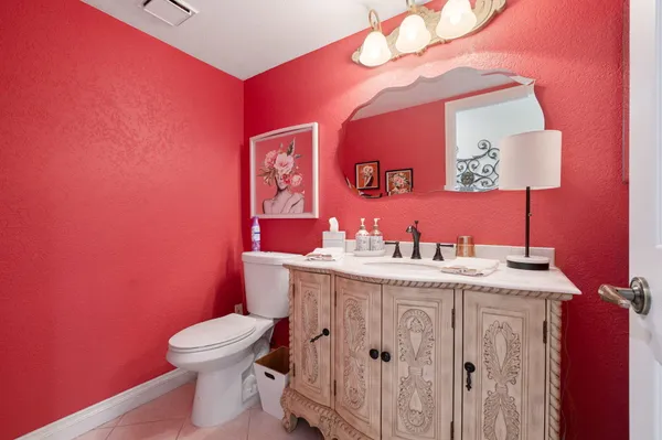 a bathroom with a granite countertop toilet sink and mirror
