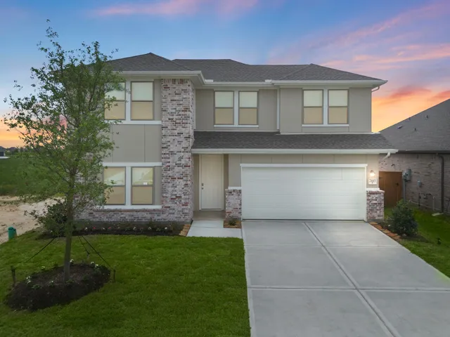 a front view of a house with a garden and yard