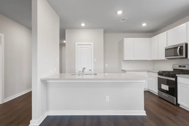 a kitchen with kitchen island a sink stainless steel appliances and cabinets